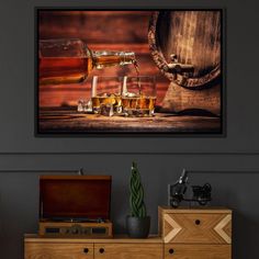 two glasses of beer are sitting on a table next to an old barrel and wooden chest