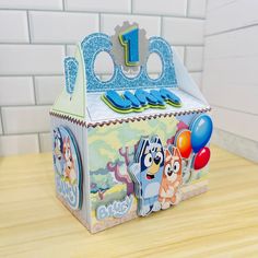 a birthday cake box with an animal theme on the top and balloons in the bottom