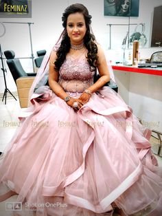 a woman sitting in a chair wearing a pink dress and holding her hands on her hips