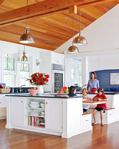 a woman and two children are in the kitchen