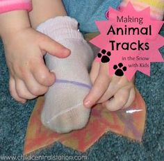 a small child is playing with an animal toy on the floor and has it's paw wrapped in a sock