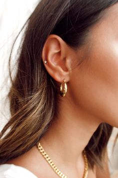 a close up of a person wearing gold jewelry