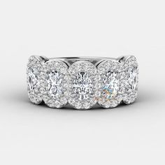 an oval diamond ring with three rows of round diamonds on the band and two rows of round