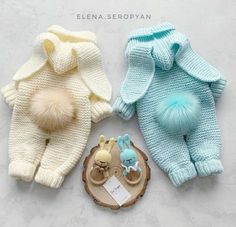 three knitted baby sweaters with pom - poms on the top and bottom