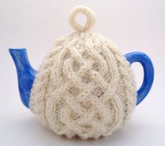 a knitted tea pot with a blue handle