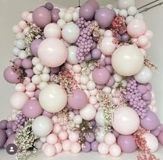 a bunch of balloons that are in the shape of a tower with flowers on it