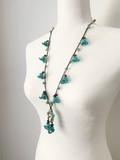 "This long flower necklace is crocheted to form turquoise tulips and combined with natural gemstones. This 16\" flower lariat necklace can add a pop of color to any outfit. It has a unique eye-catching boho style. All of BloomingSpringDesign's products are made in a smoke and pet free environment.  They are designed joyfully and delicately produced. My aim is to make you happy with your purchase, so if you are not fully satisfied with them please contact me. Your purchase will arrive gift wrapped. If you would like a handwritten note added as a part of a gift, please let me know.   If this crochet flower necklace is not exactly what you are looking for, please check the rest of my designs; https://www.etsy.com/shop/BloomingSpringDesign?section_id=26036996" Bohemian Flower Charm Necklace For Jewelry Making, Bohemian Flower Necklace With Round Beads For Beach, Handmade Green Bohemian Lariat Necklace, Bohemian Beach Flower Necklace With Round Beads, Green Handmade Bohemian Lariat Necklace, Green Bohemian Handmade Lariat Necklace, Handmade Flowers Adjustable Beach Jewelry, Bohemian Flower Necklaces With Natural Stones, Green Bohemian Flower Charm Necklace