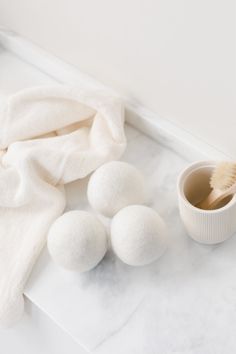 white bath balls and a cup on a marble counter