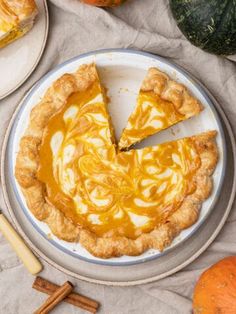 a pumpkin pie on a plate with slices cut out