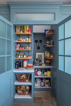 an open pantry with blue walls and shelves filled with food, drinks and condiments