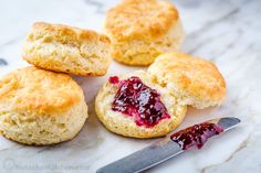 biscuits with jam on top and a knife next to them