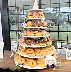 a tower of doughnuts on display in front of a window