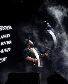 a man standing on top of a stage holding a microphone