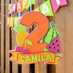 a happy 2nd birthday sign with watermelon and pineapple