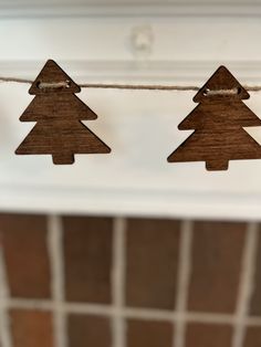 three wooden christmas trees hanging from a string