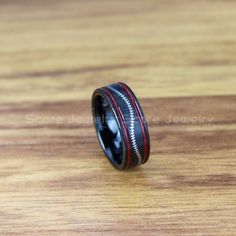 an image of a wedding ring with zippers on the inside and red inlay