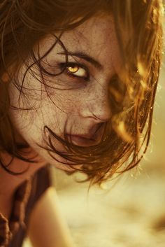 a close up of a woman's face with yellow eyes