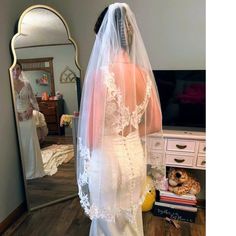 the bride is getting ready to walk down the aisle in her wedding dress and veil