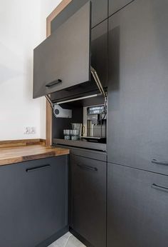 a kitchen with black cabinets and wooden counter tops