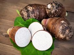 some brown and white vegetables on a green leafy surface with leaves around them,