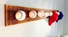 baseballs and mitts are mounted to a wooden rack on the wall above a toilet