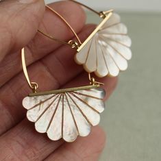 These beautiful Art Deco earrings are pure Mother of Pearl which has been carved into a simple scalloped fan shape.  The pearl has an incredible sheen and take on a subtle glow when they catch the light.  They are finished with either gold or silver plated brass earwires and are designed to hang just below the earlobe.   The length of the earrings is around 50mm (two inches).   🖤 FASTER SHIPPING 🖤 Need this fast? We offer a Faster Shipping option here: https://www.etsy.com/uk/listing/100107311 Gold Mother Of Pearl Earrings For Wedding, Mother Of Pearl Jewelry For Pierced Ears For Weddings, Wedding Jewelry For Pierced Ears In Mother Of Pearl, Art Deco Round Earrings For Wedding, Handmade Mother Of Pearl Earrings For Wedding, Art Deco Round Wedding Earrings, White Brass Pearl Earrings For Wedding, Handmade Brass Pearl Earrings For Wedding, Handmade Art Deco Earrings For Weddings