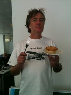 a man holding a plate with a sandwich and fork