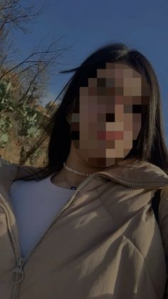 a woman with long hair wearing a tan jacket