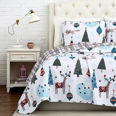 a white bed topped with a christmas themed comforter