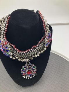 * This chunky kuchi Afghani necklace is embellished with multicolour glass stones, metallic weaving technique, and a dangling floral shaped pendant. The handmade craft is flaunting all the traditional vibes, along with a rusty silver tone. You can pair this exclusive piece with any traditional attire, as well as it would get along with any of your trendy outfits to add a pinch ethnic touch into your fashion statement. Note: The product is handmade, so slight change might occur in the actual prod Afghani Necklace, Boho Cuff Bracelet, Hand Cuff Bracelet, Kuchi Jewelry, Boho Cuff, Afghan Jewelry, Headpiece Jewelry, Traditional Attire, Silver Anklets