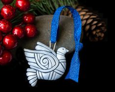 a ceramic bird ornament sitting on top of a rock next to christmas decorations