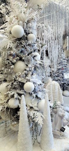 a white christmas tree is surrounded by snow and icicles