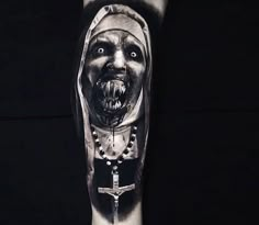 a man's arm with a creepy face and cross on it