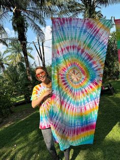 a woman holding up a colorful tie - dyed towel