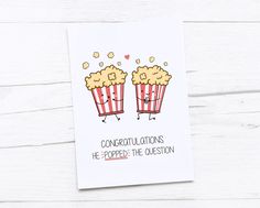 a card with two popcorns saying congratulations he popped the question