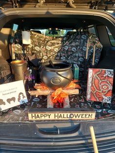 the trunk of a car is decorated with halloween decorations and cards, including a caulder