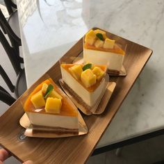 three pieces of cheesecake on a wooden plate