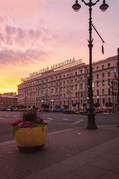 the sun is setting in front of an old building with flowers growing out of it