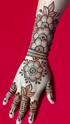 a woman's hand with henna tattoos on it