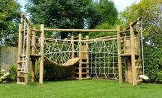 a wooden play set in the middle of a yard