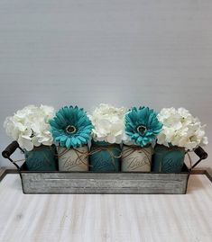 three vases with flowers in them sitting on a table