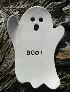 a white ceramic ghost with the word boo written on it