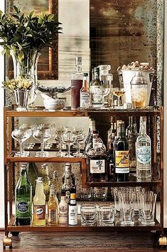 a bar cart filled with lots of bottles and glasses