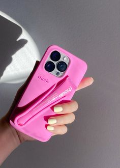 a woman's hand holding a pink case with two iphone 11 pro max cases on it