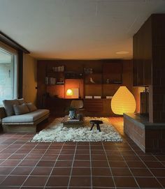 a living room filled with furniture and a fire place in front of a large window