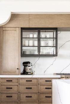 a kitchen with wooden cabinets and marble counter tops