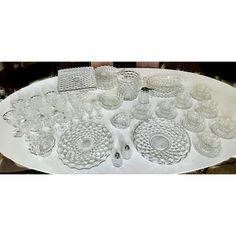 a platter filled with lots of glassware on top of a white tablecloth