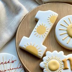 decorated cookies with the letter i and sun designs on them sitting on a wooden plate