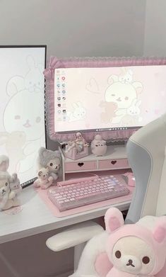 a desk with a computer, stuffed animals and a teddy bear sitting in front of it