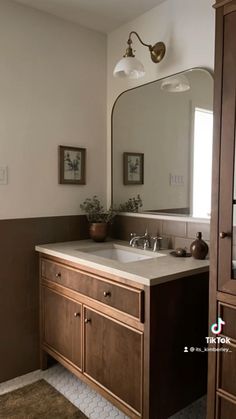 a bathroom with two sinks and a large mirror on the wall next to a cabinet